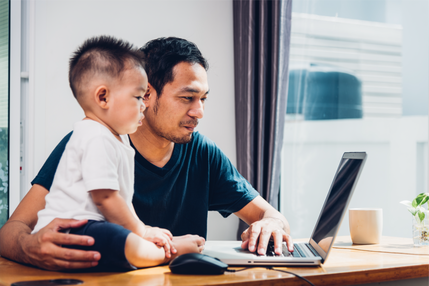 A man and his child looking at a laptop